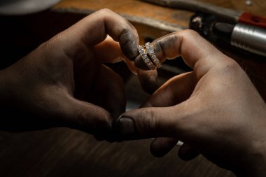 Elmas yüzük yapan bir zanaatkar. El yapımı mücevher. Elmas mücevher yüzüğü tak. Elmas yüzük üretimi. El işi atölyesinde yapılan el yapımı. Yakın çekim. siyah arkaplan.