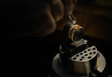 Elmas yüzük yapan bir zanaatkar. El yapımı mücevher. Elmas mücevher yüzüğü tak. Elmas yüzük üretimi. El işi atölyesinde yapılan el yapımı. Yakın çekim. siyah arkaplan.