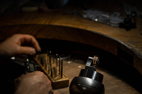 Jeweler puts diamond to golden wedding luxury ring.