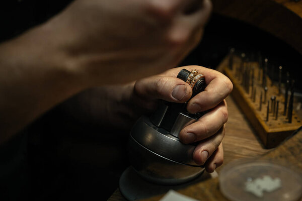 Jeweler puts diamond to golden wedding luxury ring.