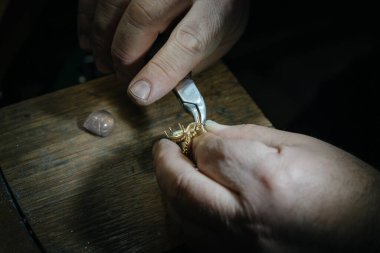 Mücevher yapımı. Yüzük tamir ediliyor. Mücevherleri yüzüğe takıyorum. Makro çekim.