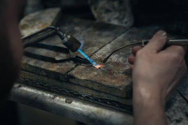 Değerli bir mücevher değerli elmas ile inşa eden bir kuyumcu el Close-up. O mücevher yapmak: hassas, işçilik ve sabır. Kavramı: altın, lüks.