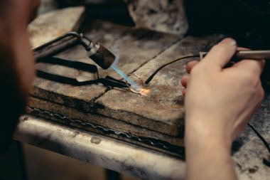 Değerli bir mücevher değerli elmas ile inşa eden bir kuyumcu el Close-up. O mücevher yapmak: hassas, işçilik ve sabır. Kavramı: altın, lüks.