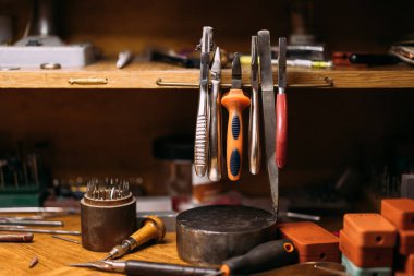 Bir atölyedeki ahşap bir masanın üzerine yerleştirilmiş çeşitli aletlerin ön görüntüsü