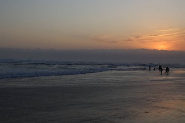 Hava kararıyordu, güneş Parangtritis plajında batmaya başlıyordu, ama insanlar hala suda oynuyorlardı ve sahildeki alacakaranlık atmosferinin keyfini çıkarıyorlardı..