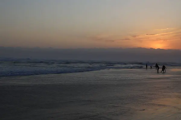 Hava kararıyordu, güneş Parangtritis plajında batmaya başlıyordu, ama insanlar hala suda oynuyorlardı ve sahildeki alacakaranlık atmosferinin keyfini çıkarıyorlardı..
