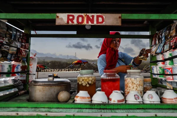 Bir Asya ülkesinde sıcak yiyecek ve içecek sunan bir satıcının portresi. Bu tüccarın en büyük teklifi taze hindistan cevizi suyu..