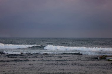 Asmara Körfezi sahilindeki ufuk çizgisi belli belirsiz gökyüzü mavisi. Dalgalar oldukça güçlü rüzgarlarla kükremeye devam etti. Malang Endonezya 'daki Teluk Asmara Plajı, henüz çok turist tarafından ziyaret edilmeyen bir plaj..