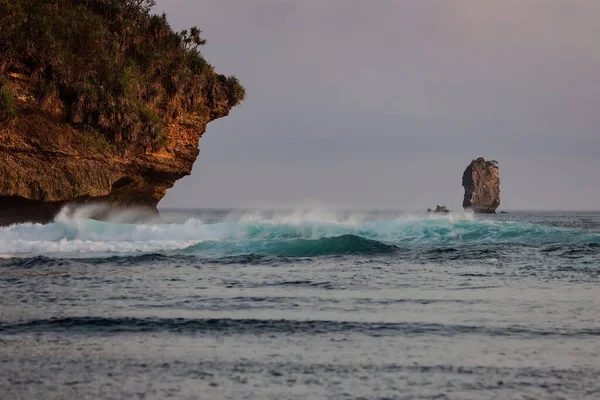 Asmara Körfezi sahilindeki ufuk çizgisi belli belirsiz gökyüzü mavisi. Dalgalar oldukça güçlü rüzgarlarla kükremeye devam etti. Malang Endonezya 'daki Teluk Asmara Plajı, henüz çok turist tarafından ziyaret edilmeyen bir plaj..