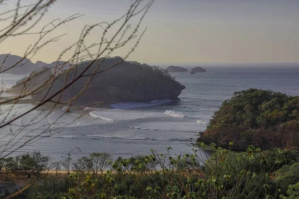 Mercan kayaları ve kırık adalardan oluşan bir derlemeden gelen kara parçası, Malang Endonezya 'nın Asmara Körfezi kıyısındaki fotoğrafladığım topraklardır. Sahil berrak su ve nispeten yüksek dalgalarla.