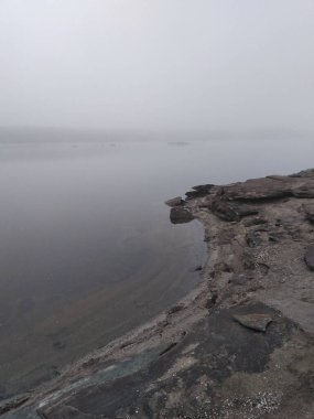 Sis. Gri bir sis içinde nehrin taşlı kıyısında. Sonbaharın sonu. Kasvetli bir ruh hali