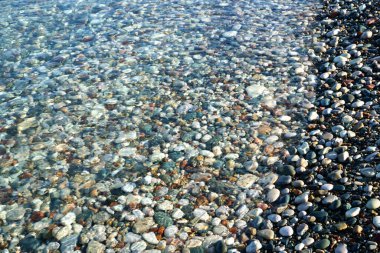 Yumuşak kristal berrak su dalgası altında deniz çakıl taşları