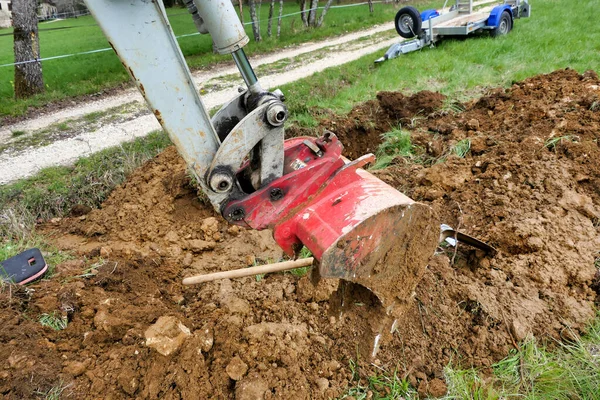 挖掘机挖掘泥土以暴露水管的破碎部分 — 图库照片