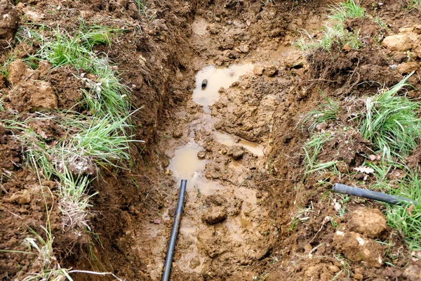 水が土中に漏れる壊れた水道管 — ストック写真