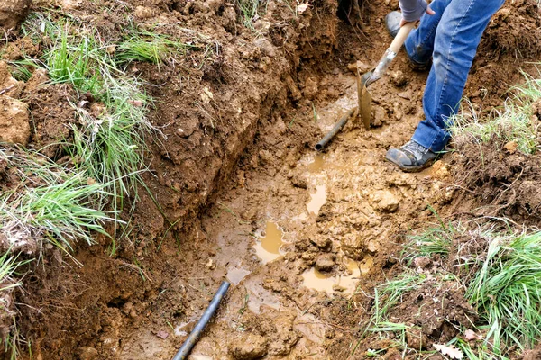 Robotnik Zeskrobuje Glebę Aby Odsłonić Wystarczającą Ilość Rur Wodnych Przeprowadzenia — Zdjęcie stockowe