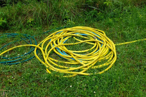 散水の間に地面に置かれた噴霧器で黄色と青の防虫剤のコイル — ストック写真