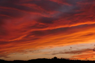 Dordogne, Fransa 'da dramatik bir gün batımı. Gökyüzü alev almış gibi görünüyor.