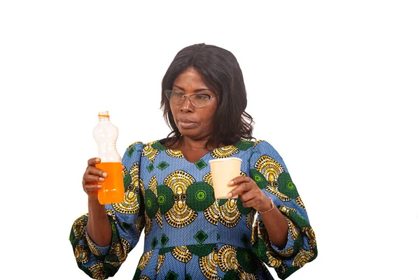 beautiful woman in traditional clothes standing on a white background a bottle of fruit juice and a disposable cup.
