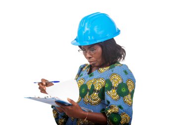female engineer in traditional clothes standing on white background wearing safety cap and checking document.