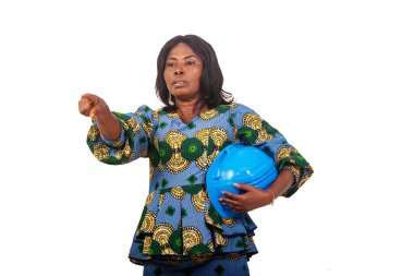 female engineer in traditional clothes standing over white background with safety cap pointing finger while talking.
