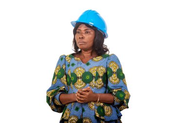 female engineer in traditional dress standing on white background wearing safety cap with pensive look.