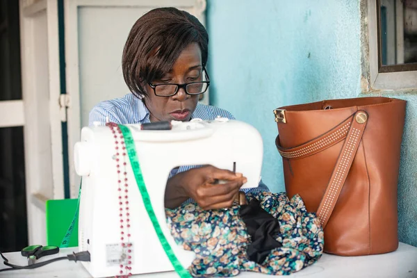 Uma Mulher Óculos Sentada Sua Oficina Costurando Roupas — Fotografia de Stock
