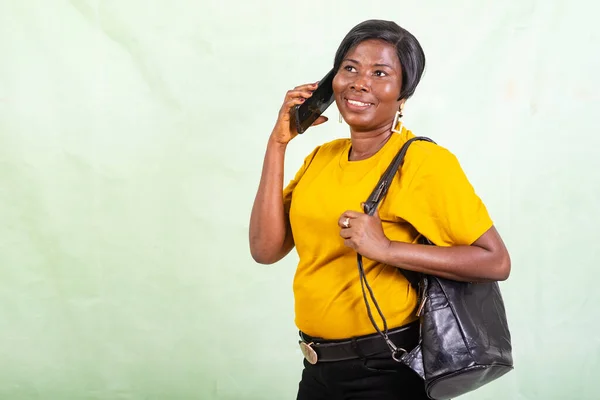 Mature Woman Yellow Shirt Standing Green Background Talking Mobile Phone — Stock Photo, Image