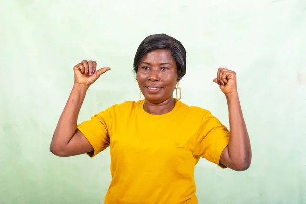 Beautiful Mature Woman Yellow Shirt Standing Green Background Pointing Thumbs — Stock Photo, Image