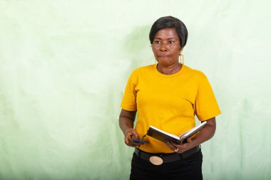 Güzel, olgun bir kadının elinde günlük ve cep telefonu tutarken, düşünceli..