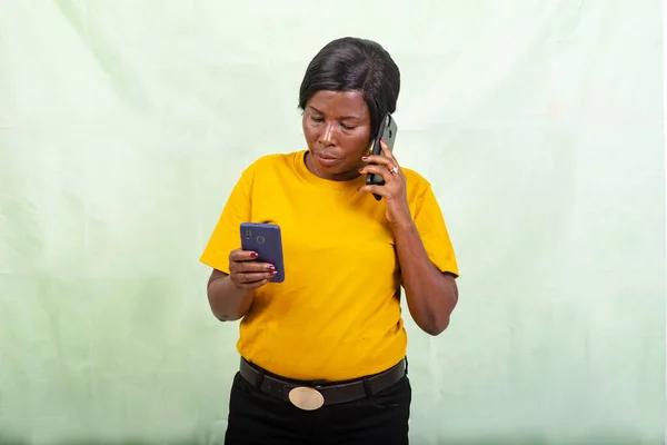 Красивая Женщина Желтой Футболке Стоящая Зеленом Фоне Разговаривающая Мобильному Телефону — стоковое фото