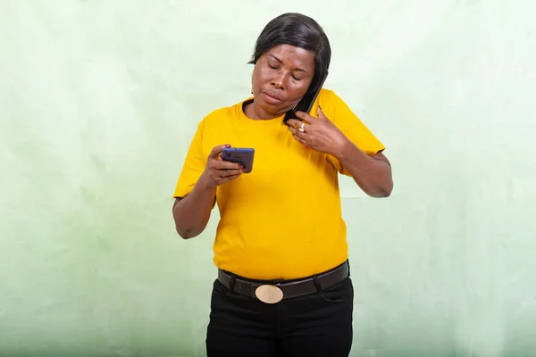 Beautiful Woman Yellow Shirt Standing Green Background Talking Mobile Phone — Stock Photo, Image