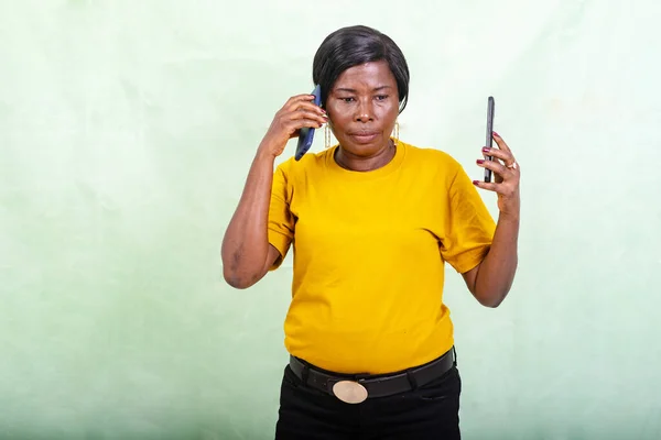 Beautiful Woman Yellow Shirt Standing Green Background Talking Cell Phone — Stock Photo, Image