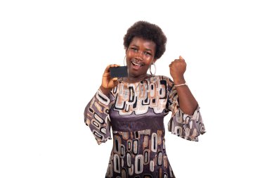 Güzel, genç bir kız öğrenci beyaz arka planda duruyor. Kredi kartı gösteriyor. Kazanan, sevinçle bağırıyor..