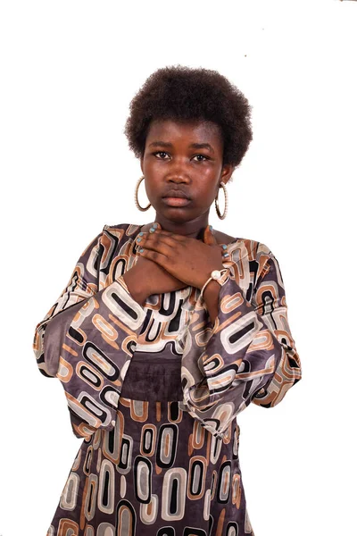 Beyaz bir arka planda afro saçlı güzel bir genç kız ellerini göğsüne koyup kameraya bakıyordu..