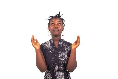 Geleneksel örgüleri olan genç bir kız beyaz arka planda durup dua ediyor..