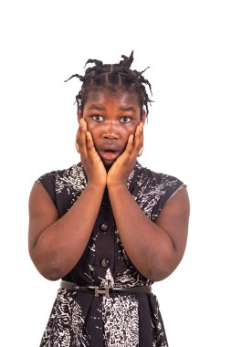 Geleneksel örgülü genç bir kız beyaz bir arka planda durup kameraya şaşkın şaşkın bakıyor..