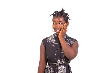 Geleneksel örgüleri olan genç bir kız beyaz bir arka planda duruyor..