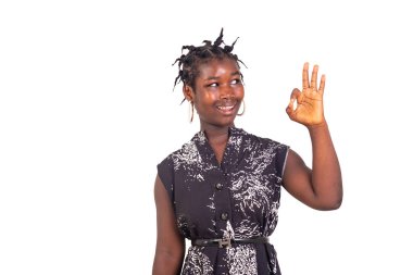 Geleneksel örgüleri olan genç bir kız beyaz bir arka planda neşeli bir şekilde gülümseyerek duruyor..