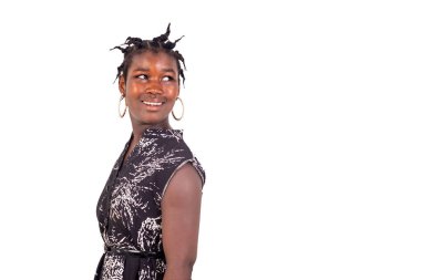 Geleneksel örgüleri olan genç bir kız beyaz bir arka planda duruyor ve gülümsüyor..