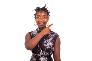 Geleneksel örgüleri olan genç bir kız beyaz arka planda durup gülümserken bir yönü işaret ediyor..