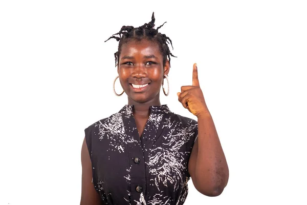 stock image young girl with the traditional braids standing on a white background pointing the finger up there while smiling.