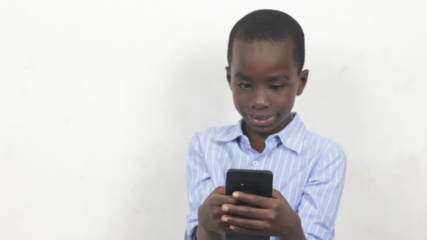 Mały Chłopiec Trzyma Telefon Komórkowy Patrzy Niego Uśmiechem — Wideo stockowe
