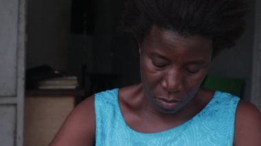 Mavi elbiseli olgun bir kadın bir sandalyede oturmuş un topları yapıyor..