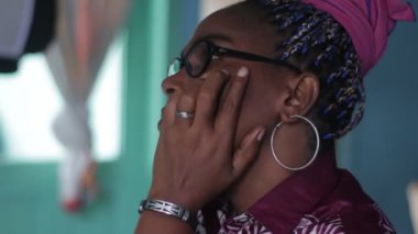 Gözlüklü güzel, olgun bir kadın evde oturup düşünüyor..