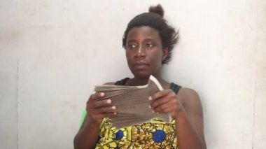 Güzel bir kadın evde oturmuş bir vantilatörle üflüyor