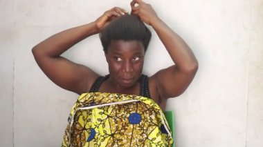 Gri arka planda yalnız oturan güzel bir kadın.