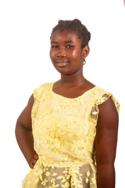 Sarı elbiseli genç kız beyaz arka planda durup kameraya gülümsüyor..