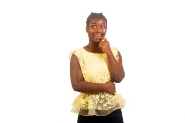 Beyaz bir arka planda duran güzel bir genç kız gülümserken düşünüyor..