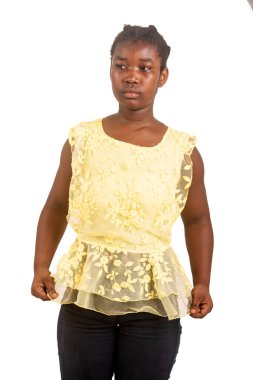 Sarı korsajlı güzel bir kız öğrenci elinde çiçeğinin ucuyla beyaz bir arka planda duruyor..