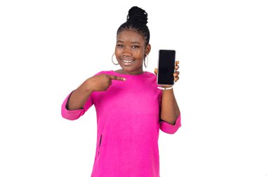 Beyaz arka planda duran pembe gecelikli genç kız cep telefonuna gülümsüyor..